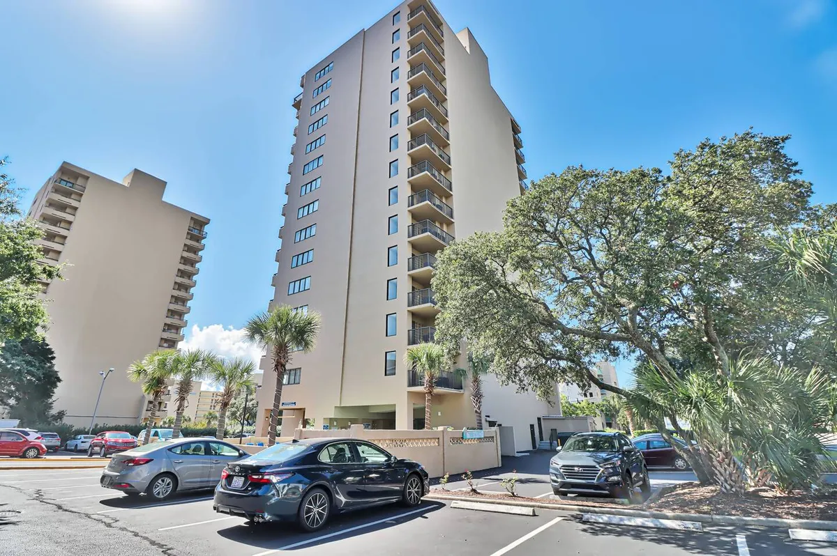 This image showcases the exterior of a tall building flanked by palm trees and a parking lot, with a welcoming vibe. It suggests the property’s proximity to the action and ease of access for groups arriving together.