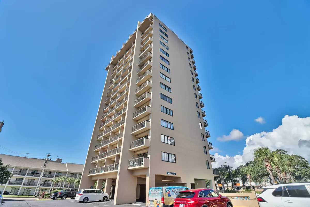 A modern building structure rises with multiple balconies and large windows, suggesting opportunities for guests to soak in views and relax outdoors. The design and elevation evoke the sense of a contemporary resort, ideal for returning from a day on the golf course.
